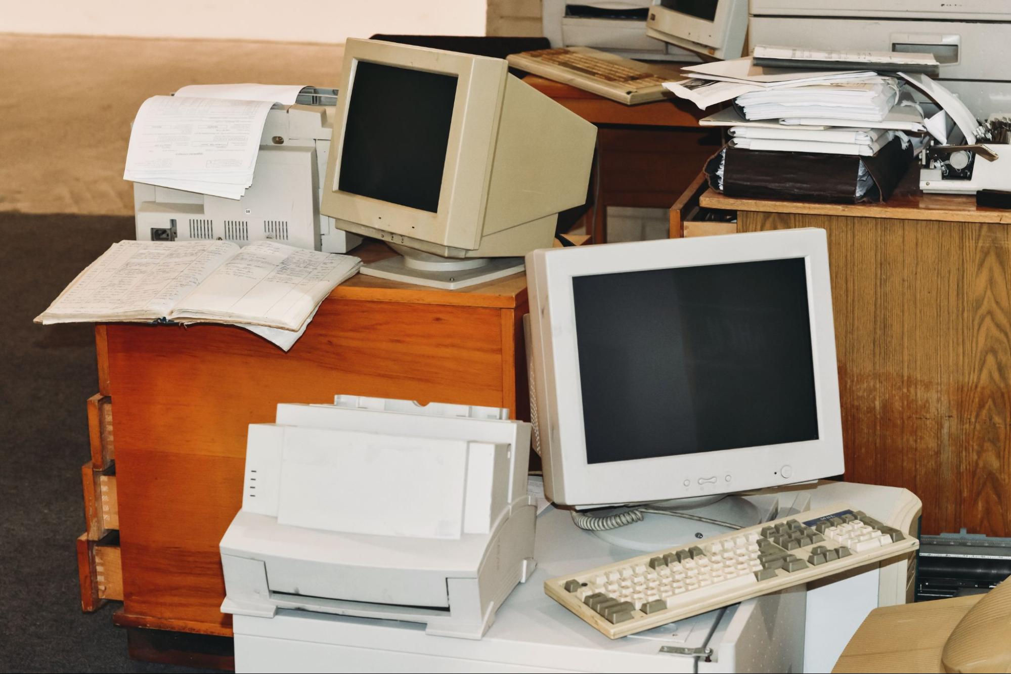 Older computers stacked at office ready for an upgrade