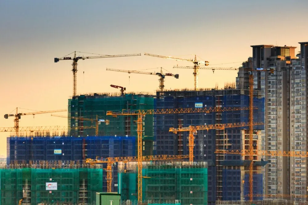 Construction cranes over a Los Angeles high-rise development at sunset