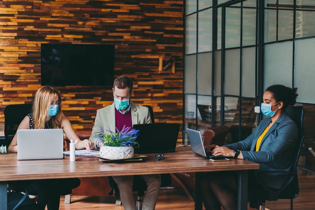 Business people working with face masks in the office during COVID-19 pandemic